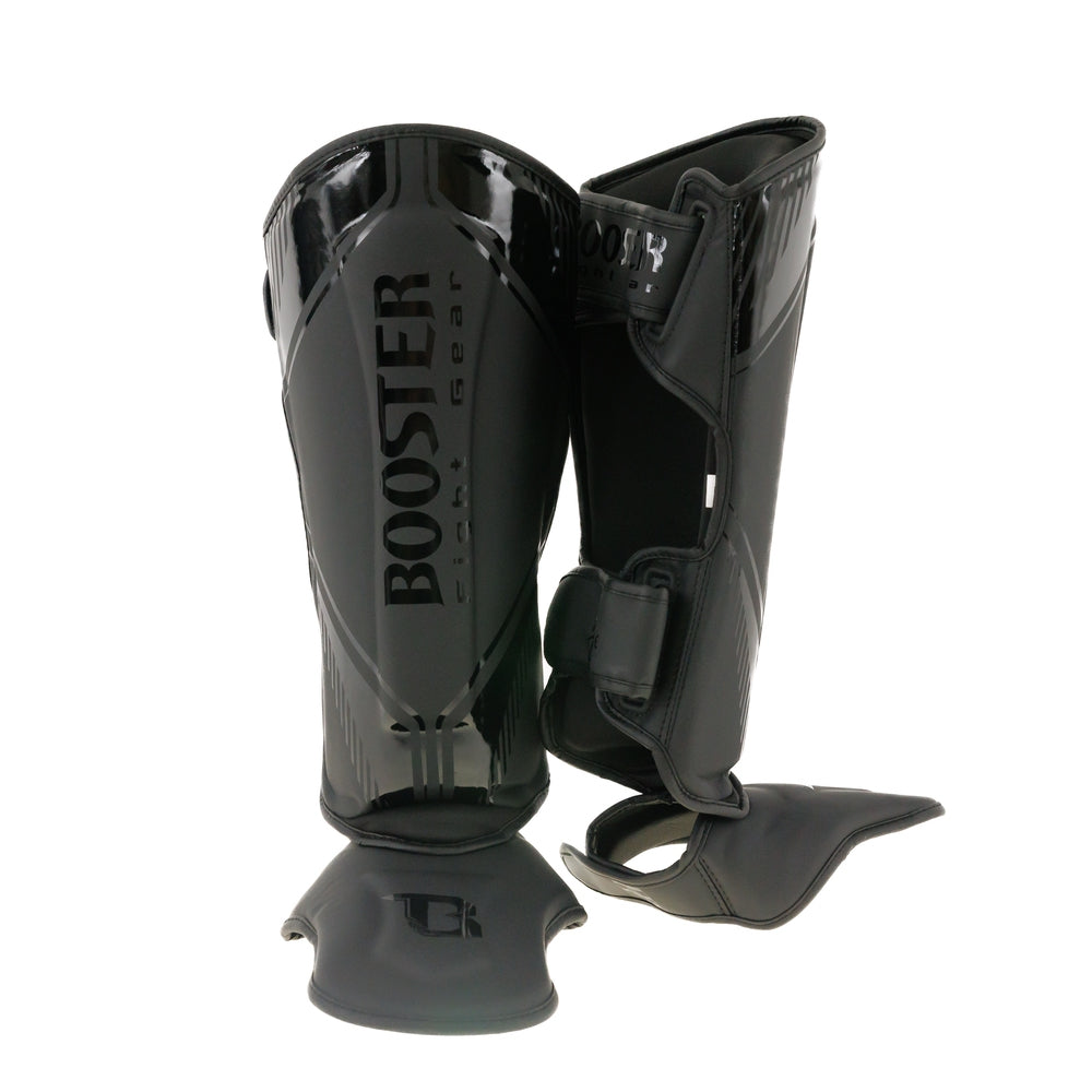 Schwarze Women Shin Guards für Muay Thai einer in frontal und einer in seitlicher Ansicht auf weißem Hintergrund