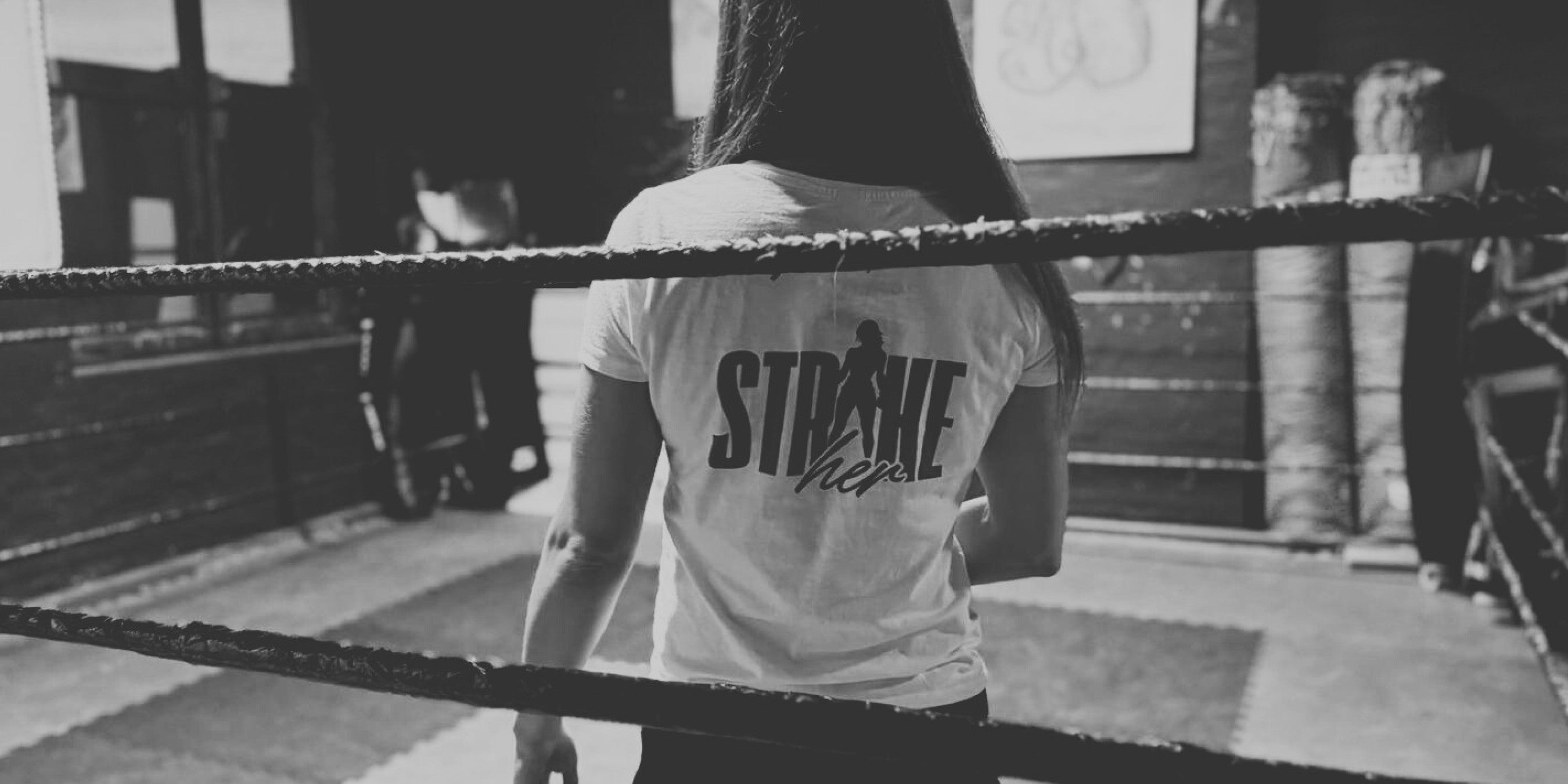 Frau im Boxring mit STRIKE HER Sport Shirt. Female Fighter.